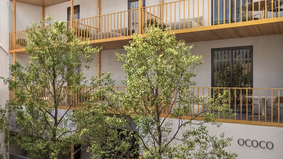 Pátio interno do Hotel Ilhas Canárias com varandas de madeira e árvores, em render 3D da Render Fabrik Pátio interno do Hotel Ilhas Canárias com varandas de madeira e árvores, em render 3D da Render Fabrik