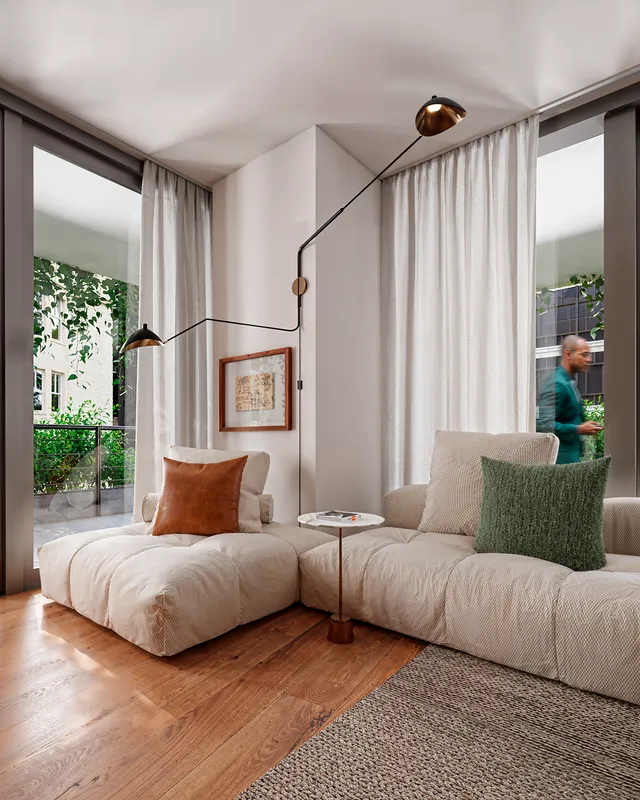 Render 3D del salón de los Pisos piloto con sofá modular rinconero, aplique articulado y ventanales