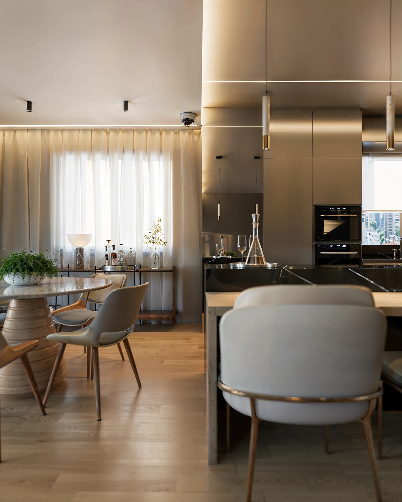 Salão de festas do Liv Green Residence em render 3D, com mesa redonda de pedestal e cozinha gourmet em marcenaria metálica