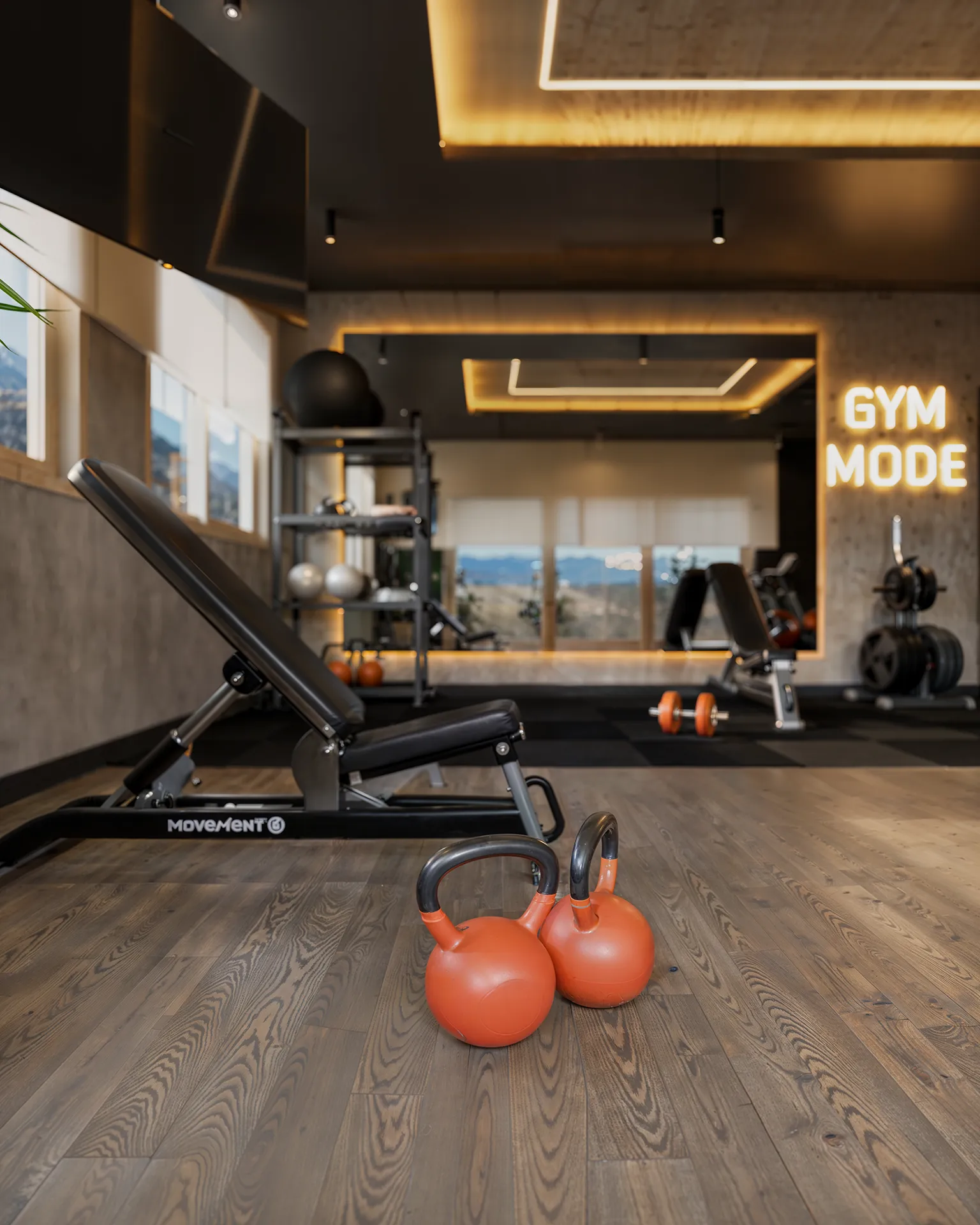 Render 3D do espaço fitness do Liv Green Residence com piso de madeira, espelho iluminado e halteres