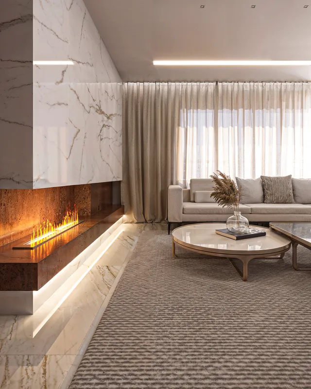 Living dos Apartamentos Modelos em render 3D com lareira a etanol, revestimento marmorizado e sofá claro